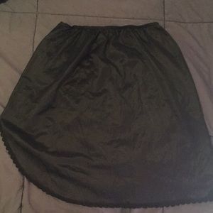 Vintage black nylon half slip with curved hem.